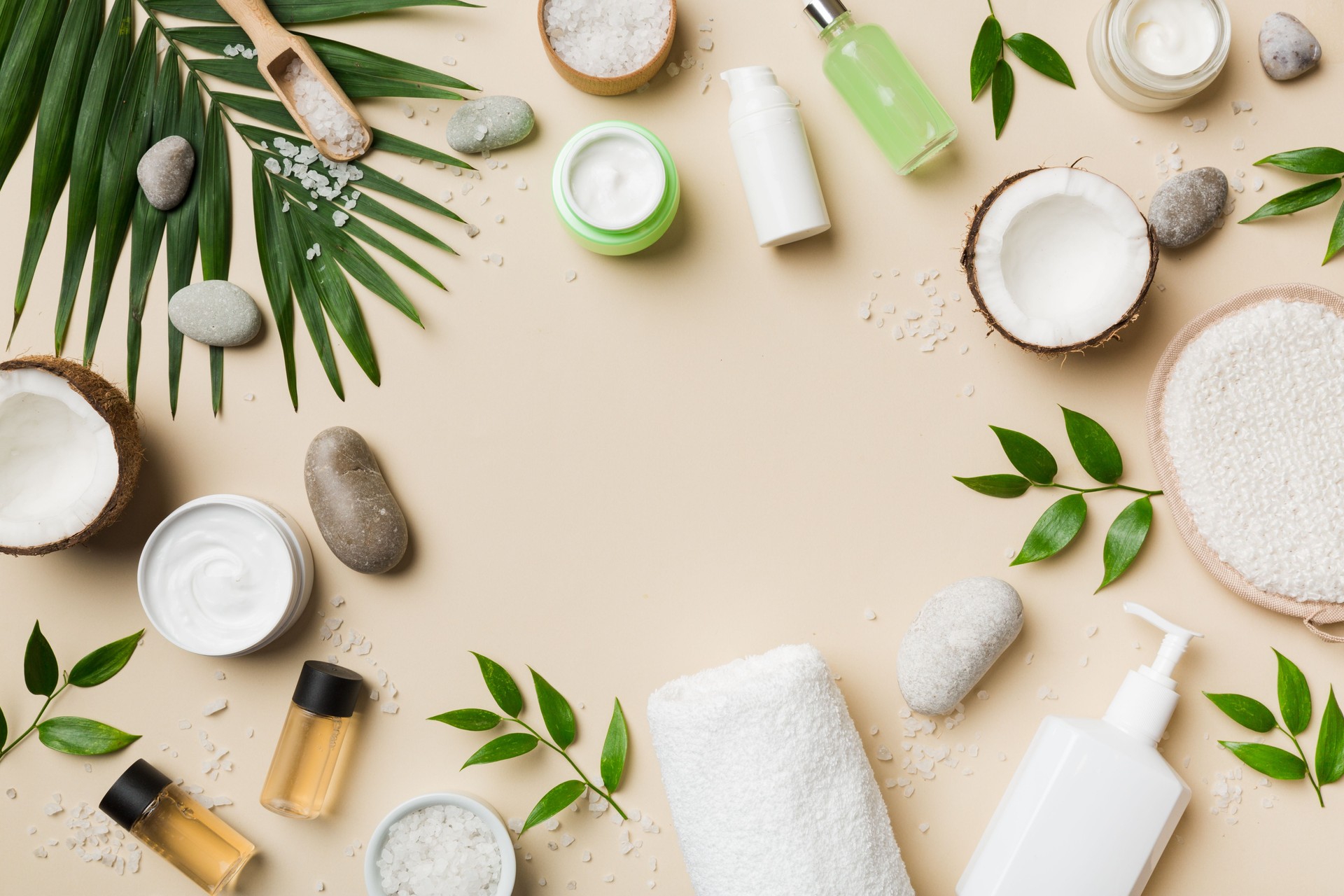 Coconut with jars of coconut oil and cosmetic cream on colored background. Top view. Free space for your text. Natural spa coconut cosmetics and organic treatment concept Coconut Spa composition