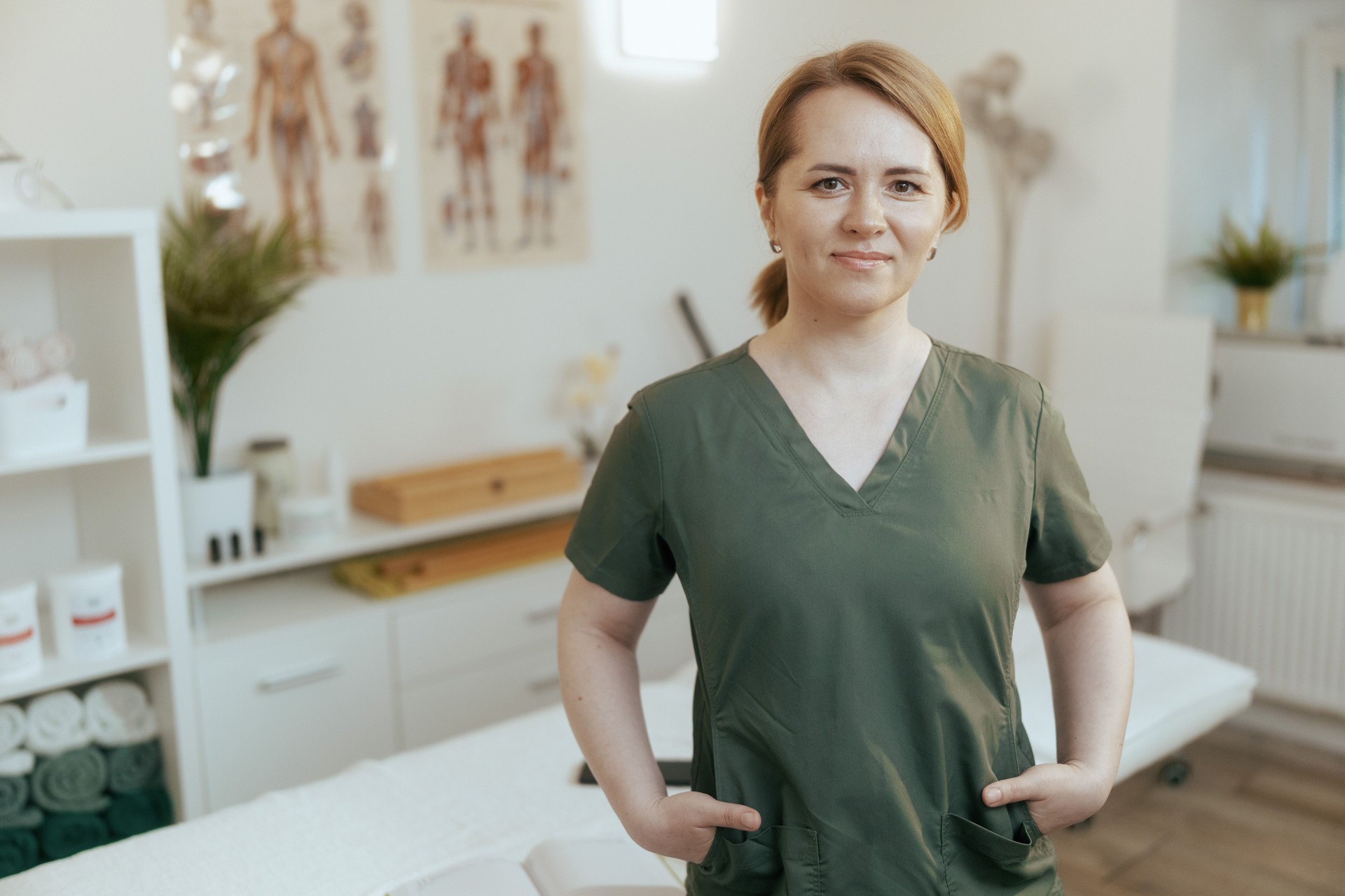 happy female medical massage therapist looking at camera