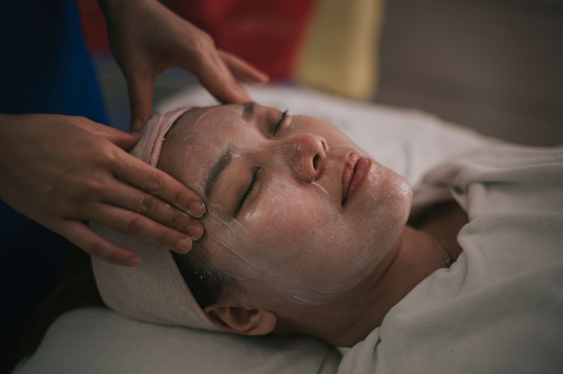 Asiática china mujer esteticista limpieza limpiando haciendo tratamiento facial para su cliente en el salón de belleza facial