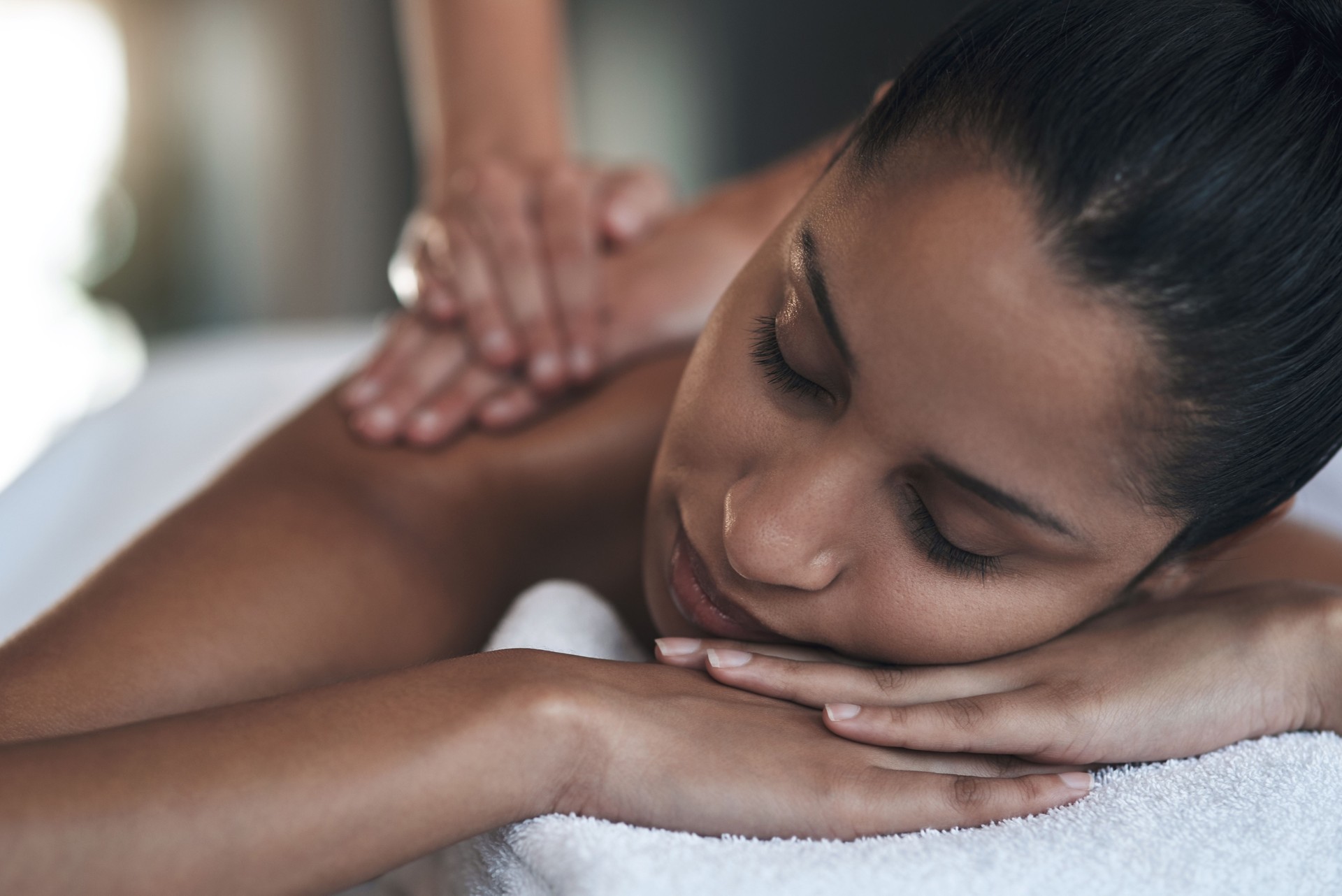 Foto de una mujer joven recibiendo un masaje de espalda en un spa